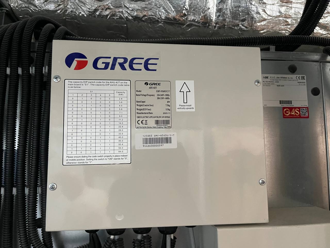 Unitate de climatizare Gree instalată într-un spațiu tehnic, conectată la trasee de cabluri și integrată într-un sistem de ventilație sau climatizare.